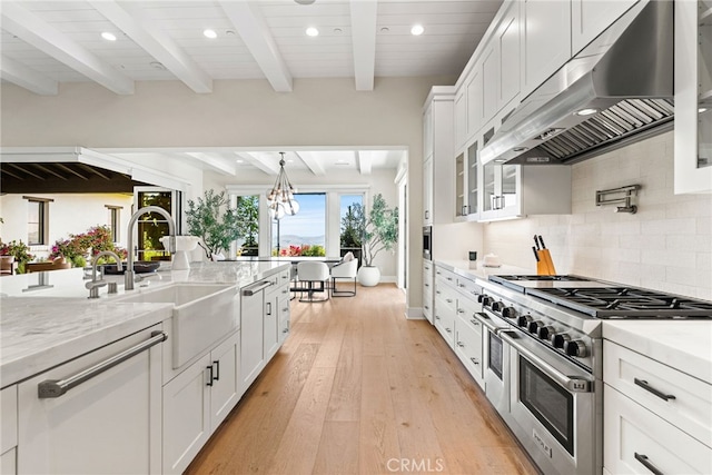 30 Catalina Vista Rd, Ladera Ranch, CA 92694 - kitchen with ventilation hood, range with two ovens, white cabinets, backsplash, and white dishwasher