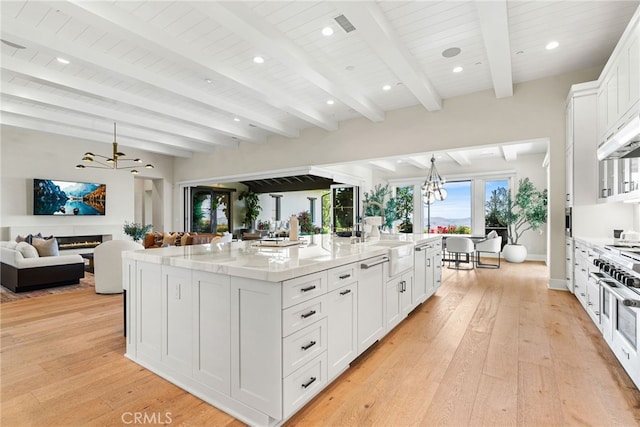 30 Catalina Vista Rd, Ladera Ranch, CA 92694 - kitchen with a chandelier, light wood-type flooring, white cabinets, a lit fireplace, and open floor plan