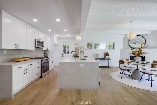 4532 Zella Ln, Yorba Linda, CA 92886 - kitchen with stainless steel appliances, white cabinets, light wood-style flooring, recessed lighting, and a wood ceiling with exposed beams