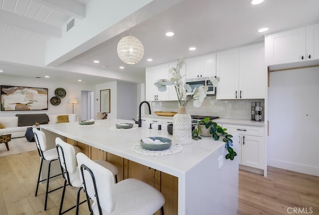 4532 Zella Ln, Yorba Linda, CA 92886 - kitchen with beamed ceiling, light wood-style floors, white cabinets, recessed lighting, and decorative backsplash