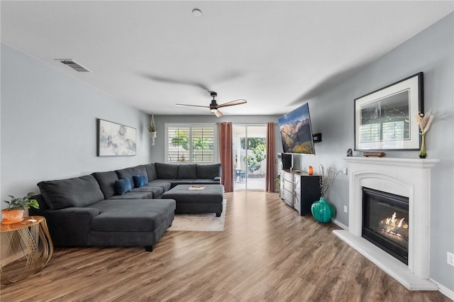 4040 Quartzite Ln, San Bernardino, CA 92407 - living area with wood finished floors, a glass covered fireplace, and a ceiling fan