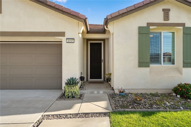 4040 Quartzite Ln, San Bernardino, CA 92407 - entrance to property with stucco siding, an attached garage, concrete driveway, and a tiled roof