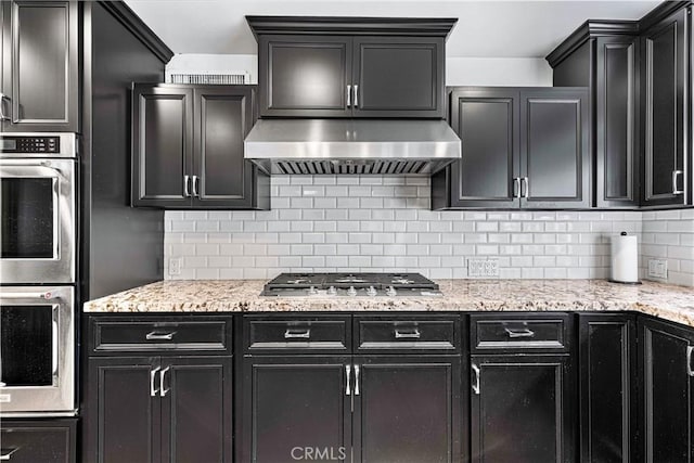 17437 Tarzana St, Encino, CA 91316 - kitchen featuring stainless steel appliances, extractor fan, and dark cabinetry