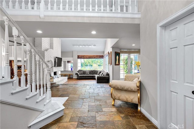 17437 Tarzana St, Encino, CA 91316 - foyer featuring plenty of natural light, stone tile flooring, a towering ceiling, a brick fireplace, and stairway