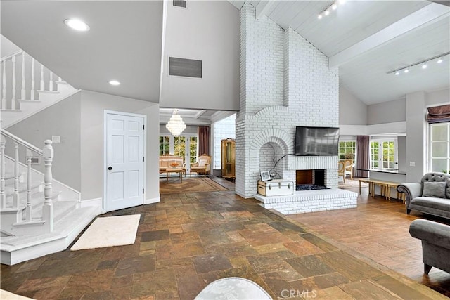 17437 Tarzana St, Encino, CA 91316 - living area with rail lighting, high vaulted ceiling, stairs, stone tile floors, and a brick fireplace