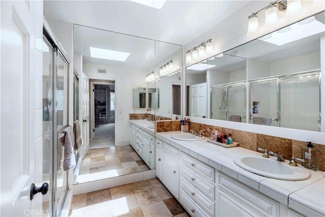 17437 Tarzana St, Encino, CA 91316 - bathroom featuring a skylight, double vanity, and a stall shower