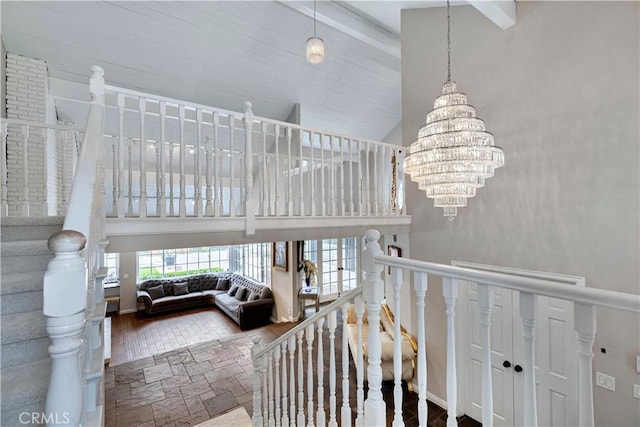 17437 Tarzana St, Encino, CA 91316 - staircase featuring high vaulted ceiling, a chandelier, beam ceiling, and wood finished floors