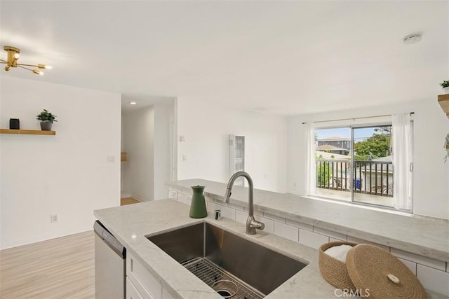 4727 W 147th St Unit 133, Lawndale, CA 90260 - kitchen with stainless steel dishwasher, light stone countertops, light wood finished floors, and white cabinets