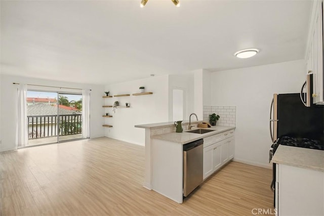 4727 W 147th St Unit 133, Lawndale, CA 90260 - kitchen with appliances with stainless steel finishes, a peninsula, white cabinets, light countertops, and light wood-type flooring