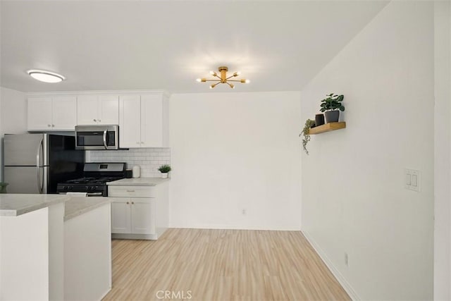 4727 W 147th St Unit 133, Lawndale, CA 90260 - kitchen featuring appliances with stainless steel finishes, light countertops, tasteful backsplash, white cabinetry, and light wood-style flooring