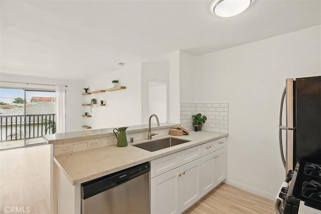 4727 W 147th St Unit 133, Lawndale, CA 90260 - kitchen with dishwasher, freestanding refrigerator, gas stove, a peninsula, and light wood finished floors