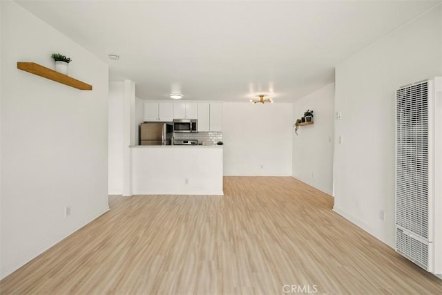 4727 W 147th St Unit 133, Lawndale, CA 90260 - unfurnished living room featuring a heating unit and light wood-style flooring