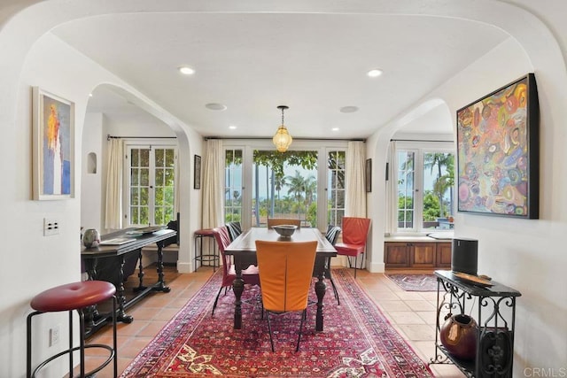 308 Sunset Dr Unit A, Encinitas, CA 92024 - dining space with french doors, light tile patterned floors, arched walkways, and recessed lighting