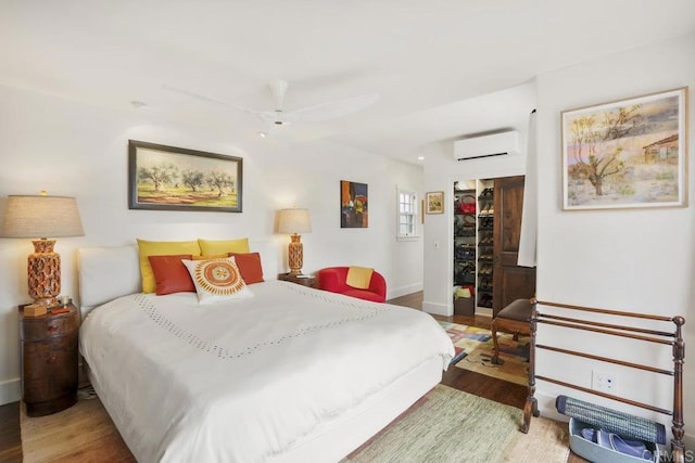 308 Sunset Dr Unit A, Encinitas, CA 92024 - bedroom with a wall mounted air conditioner, wood finished floors, a spacious closet, a closet, and ceiling fan