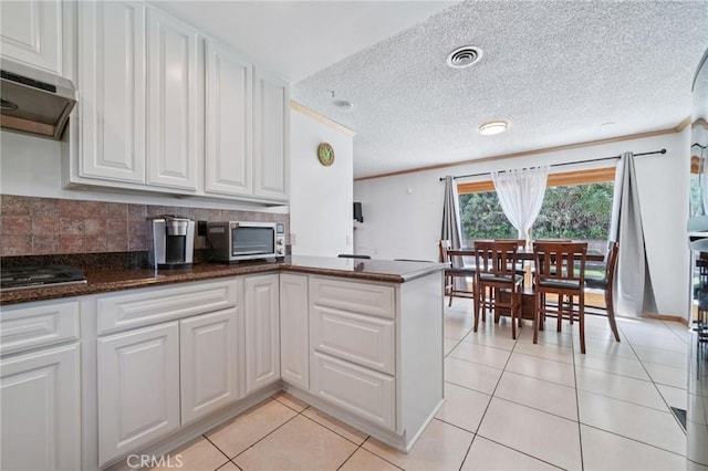 18472 Dragonera Dr, Rowland Heights, CA 91748 - kitchen featuring extractor fan, light tile patterned floors, white cabinets, a peninsula, and crown molding