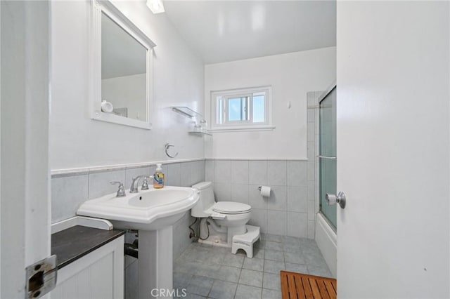 18472 Dragonera Dr, Rowland Heights, CA 91748 - bathroom with tile patterned floors, tile walls, bath / shower combo with glass door, and a wainscoted wall