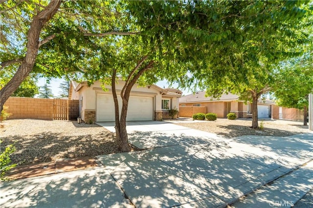 45722 Palm Ln, Lancaster, CA 93535 - view of front of house with driveway, stucco siding, an attached garage, and stone siding