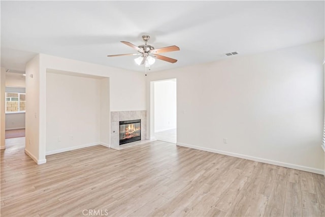 45722 Palm Ln, Lancaster, CA 93535 - unfurnished living room featuring a ceiling fan, light wood-type flooring, and a tiled fireplace