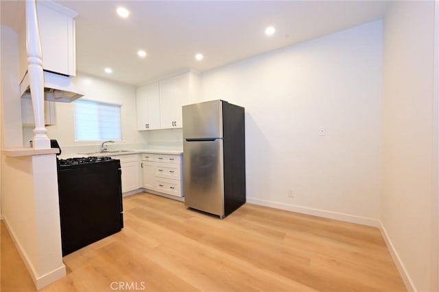 833 W Duarte Rd Unit 11, Arcadia, CA 91007 - kitchen with freestanding refrigerator, black gas range oven, white cabinets, light wood-style flooring, and light countertops