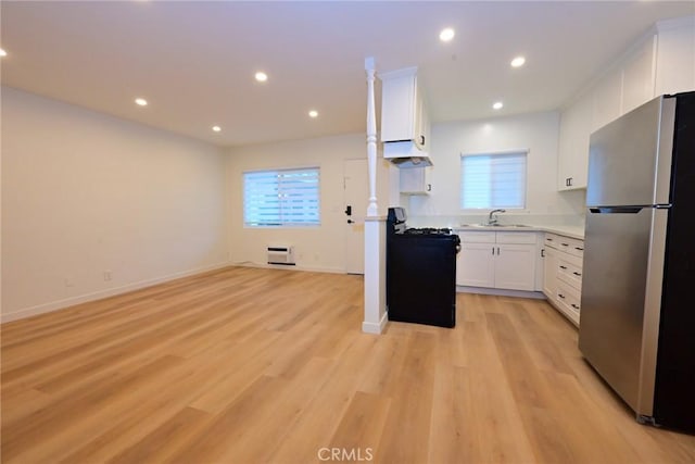 833 W Duarte Rd Unit 11, Arcadia, CA 91007 - kitchen featuring freestanding refrigerator, under cabinet range hood, black gas range oven, white cabinets, and light wood-style flooring