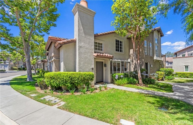 17 Indigo Pl, Aliso Viejo, CA 92656 - mediterranean / spanish home with a tiled roof, a chimney, stucco siding, a front lawn, and a residential view