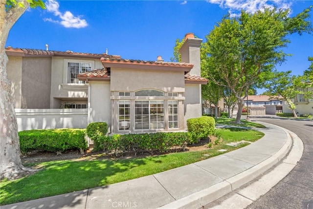 17 Indigo Pl, Aliso Viejo, CA 92656 - rear view of house featuring stucco siding, a chimney, and a tile roof