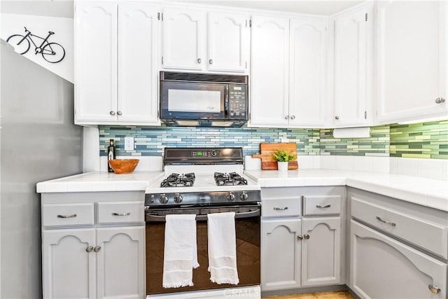 17 Indigo Pl, Aliso Viejo, CA 92656 - kitchen with black microwave, range with gas stovetop, and white cabinetry