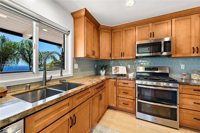 32055 Virginia Way, Laguna Beach, CA 92651 - kitchen with appliances with stainless steel finishes, dark stone counters, decorative backsplash, brown cabinets, and recessed lighting