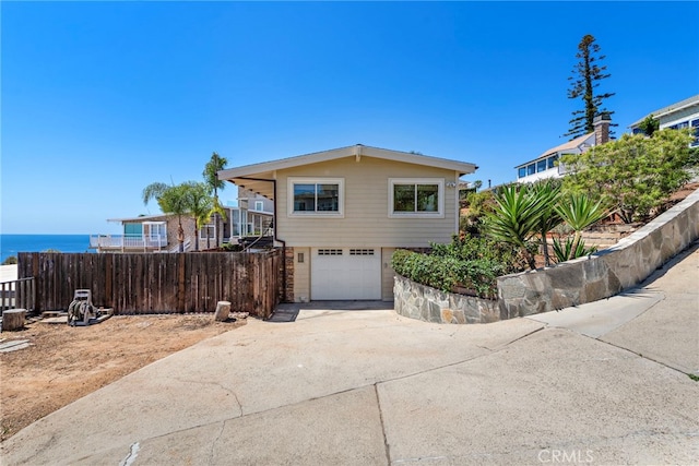 32055 Virginia Way, Laguna Beach, CA 92651 - view of front of house with an attached garage, concrete driveway, and a water view