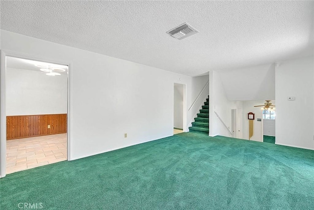 9465 Palo Verde Ave, Fontana, CA 92335 - empty room with carpet, stairway, ceiling fan, a textured ceiling, and wood walls