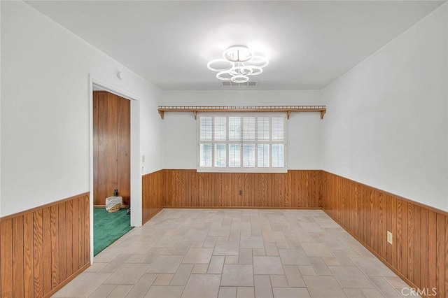 9465 Palo Verde Ave, Fontana, CA 92335 - spare room featuring wainscoting, wood walls, and a chandelier