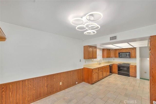 9465 Palo Verde Ave, Fontana, CA 92335 - kitchen featuring stove, stainless steel microwave, light countertops, brown cabinetry, and black dishwasher