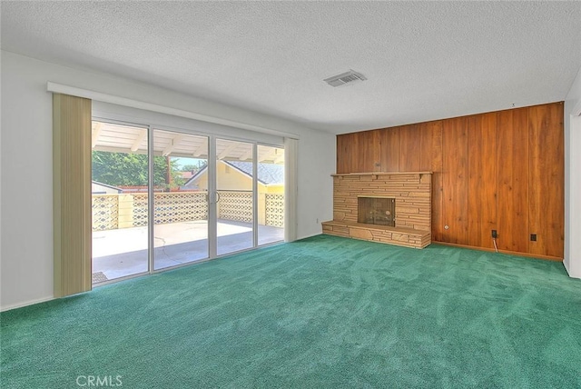 9465 Palo Verde Ave, Fontana, CA 92335 - unfurnished living room featuring wood walls, carpet floors, a stone fireplace, and a textured ceiling