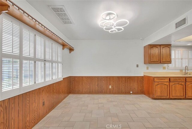 9465 Palo Verde Ave, Fontana, CA 92335 - unfurnished dining area with wooden walls, wainscoting, and a chandelier