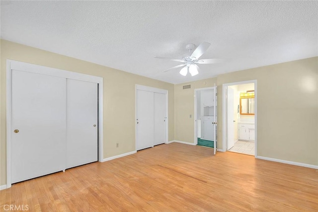 9465 Palo Verde Ave, Fontana, CA 92335 - unfurnished bedroom with light wood-style floors, two closets, a textured ceiling, ensuite bath, and ceiling fan