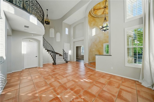 4451 Birdie Dr, Corona, CA 92883 - foyer entrance featuring a high ceiling, a chandelier, tile patterned flooring, stairway, and arched walkways