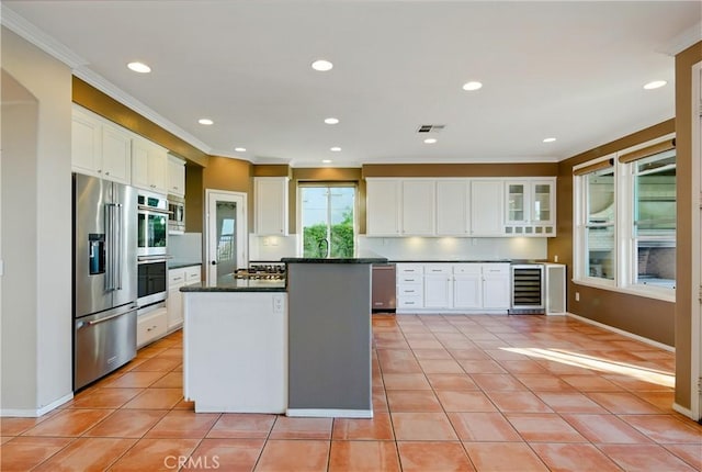 4451 Birdie Dr, Corona, CA 92883 - kitchen with stainless steel appliances, beverage cooler, crown molding, white cabinetry, and light tile patterned floors