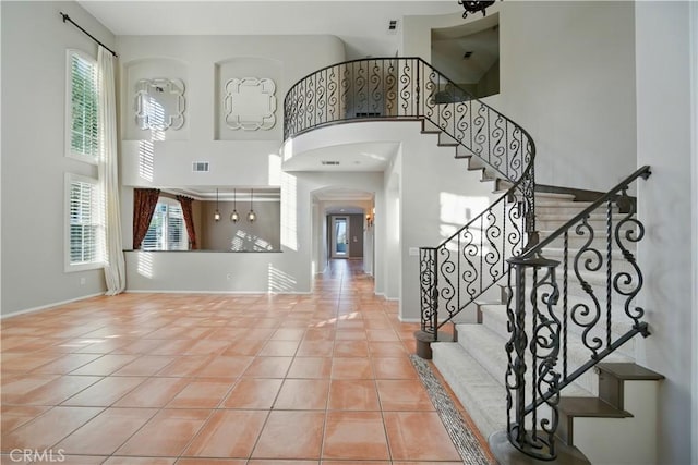 4451 Birdie Dr, Corona, CA 92883 - tiled foyer entrance with a high ceiling, arched walkways, plenty of natural light, and stairs