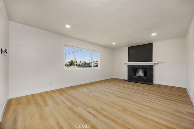 3009 Delburn St, Bakersfield, CA 93304 - unfurnished living room with light wood-style flooring, a fireplace, and recessed lighting