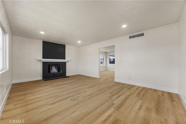 3009 Delburn St, Bakersfield, CA 93304 - unfurnished living room with light wood-style flooring, healthy amount of natural light, recessed lighting, and a brick fireplace
