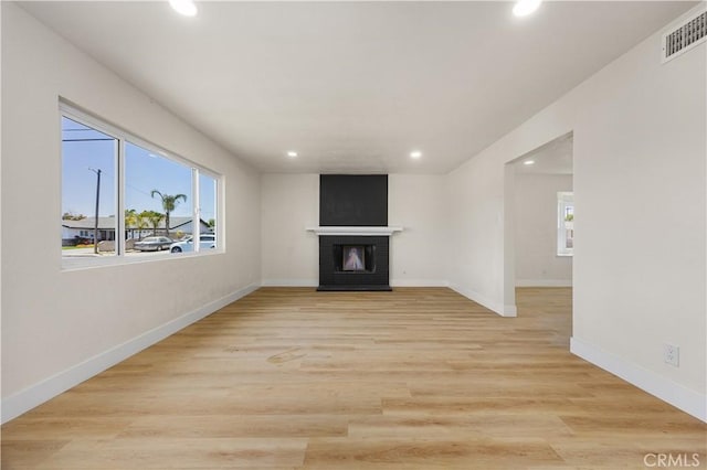 3009 Delburn St, Bakersfield, CA 93304 - unfurnished living room featuring recessed lighting, plenty of natural light, a fireplace, and light wood-type flooring