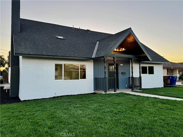 3009 Delburn St, Bakersfield, CA 93304 - back of property at dusk with a yard, a shingled roof, a chimney, and stucco siding