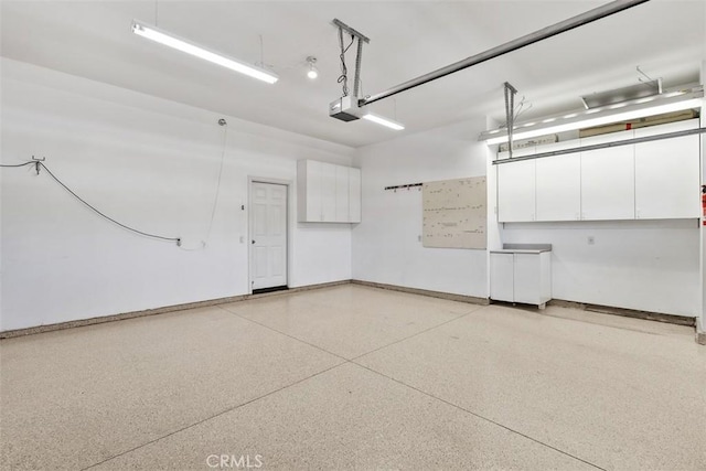 29530 Winding Brook Dr, Menifee, CA 92584 - garage with a garage door opener and baseboards