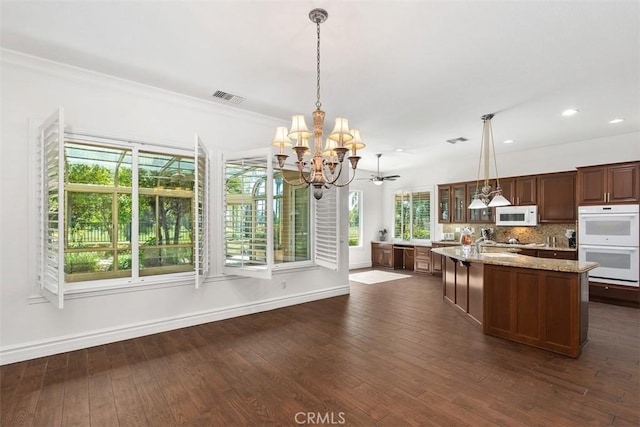 29530 Winding Brook Dr, Menifee, CA 92584 - kitchen featuring white appliances, a chandelier, dark wood-style flooring, decorative backsplash, and pendant lighting