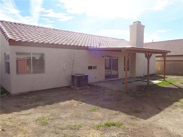 3407 Amber St, Rosamond, CA 93560 - back of house with stucco siding, a chimney, a tile roof, and a patio area