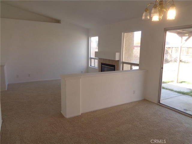 3407 Amber St, Rosamond, CA 93560 - unfurnished living room with carpet flooring, a tiled fireplace, and a chandelier