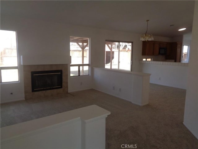 3407 Amber St, Rosamond, CA 93560 - unfurnished living room with carpet floors, a tile fireplace, plenty of natural light, and a chandelier