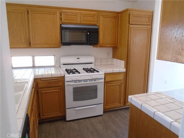 3407 Amber St, Rosamond, CA 93560 - kitchen with black microwave, white gas range oven, tile counters, and dark wood-style floors