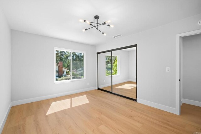 10594 Rookwood Dr, San Diego, CA 92131 - unfurnished bedroom featuring a chandelier, light wood finished floors, and a closet