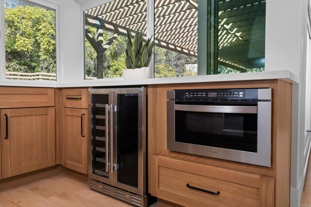 10594 Rookwood Dr, San Diego, CA 92131 - kitchen featuring beverage cooler, light wood-style flooring, light countertops, and oven